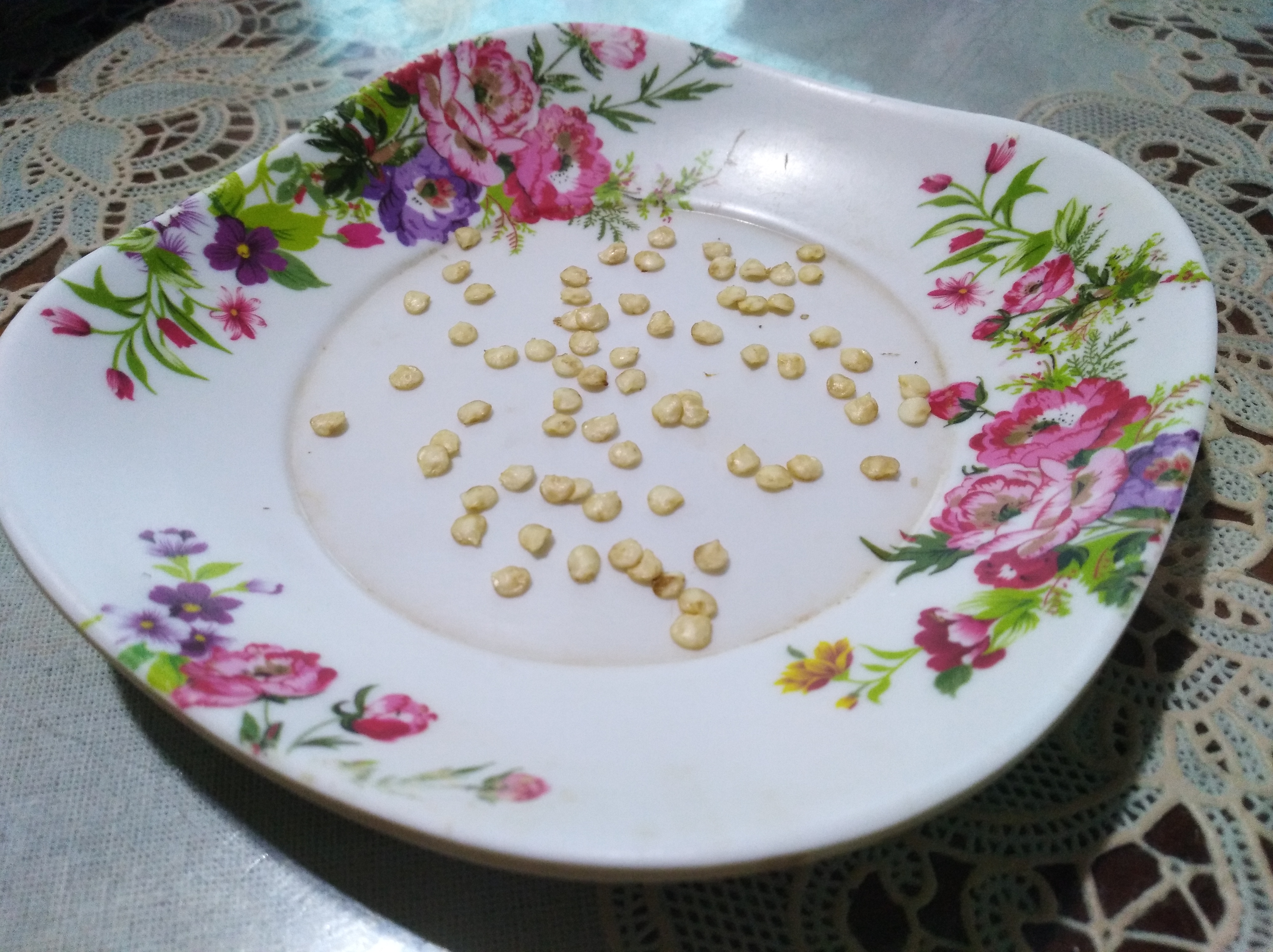 Pepper seeds drying on a flower-decorated plate